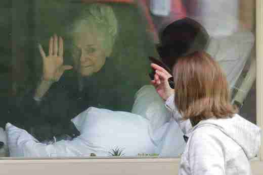 Judie Shape, left, who has tested positive for the coronavirus, waves to her daughter, Lori Spencer, right, Wednesday, March 11, 2020, as they visit on the phone and look at each other through a window at the Life Care Center.