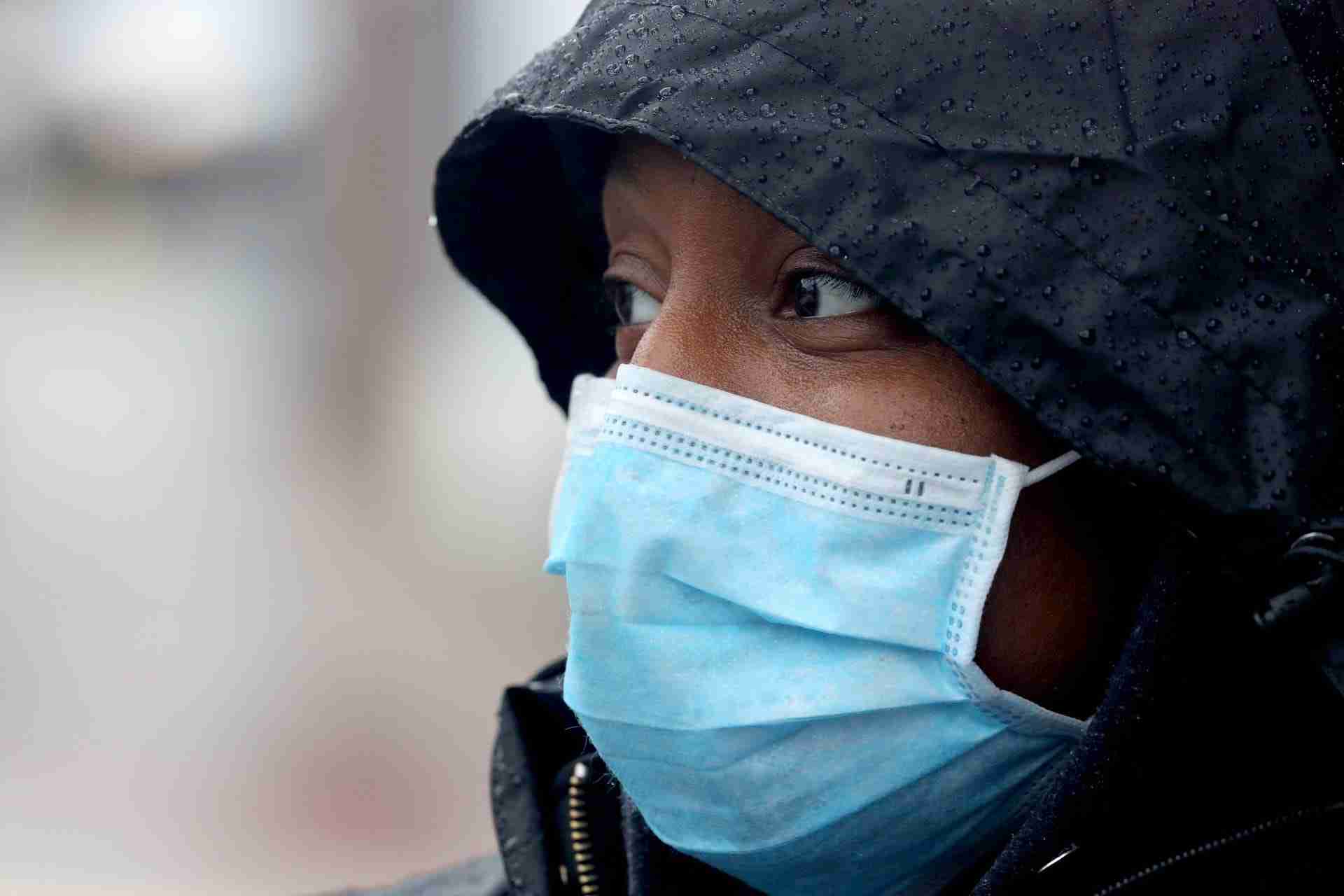 Mail carrier Jasmine Armstrong wears a mask while delivering the mail in Peekskill, N.Y. March 23, 2020. Armstrong says the the postal service supplies gloves and a mask, and she is maintaining the recommended six feet from others in order to avoid being exposed to the Covid-19 virus.