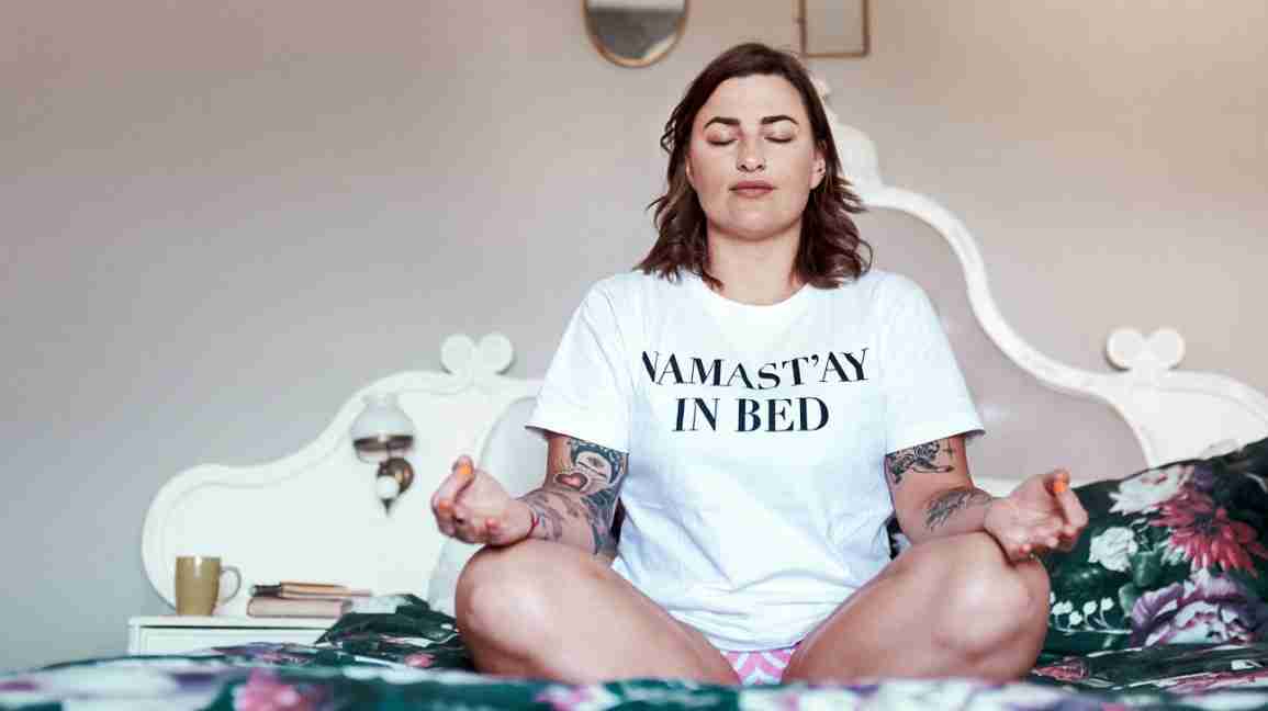 woman doing yoga on bed