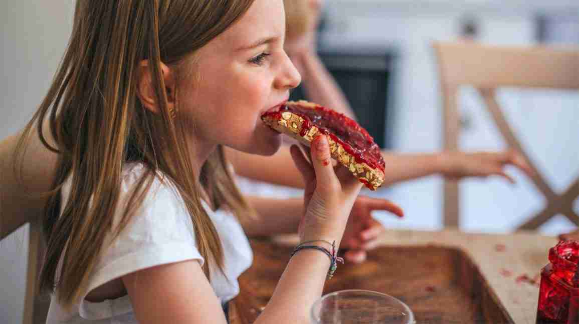Girl eating a bread with jam