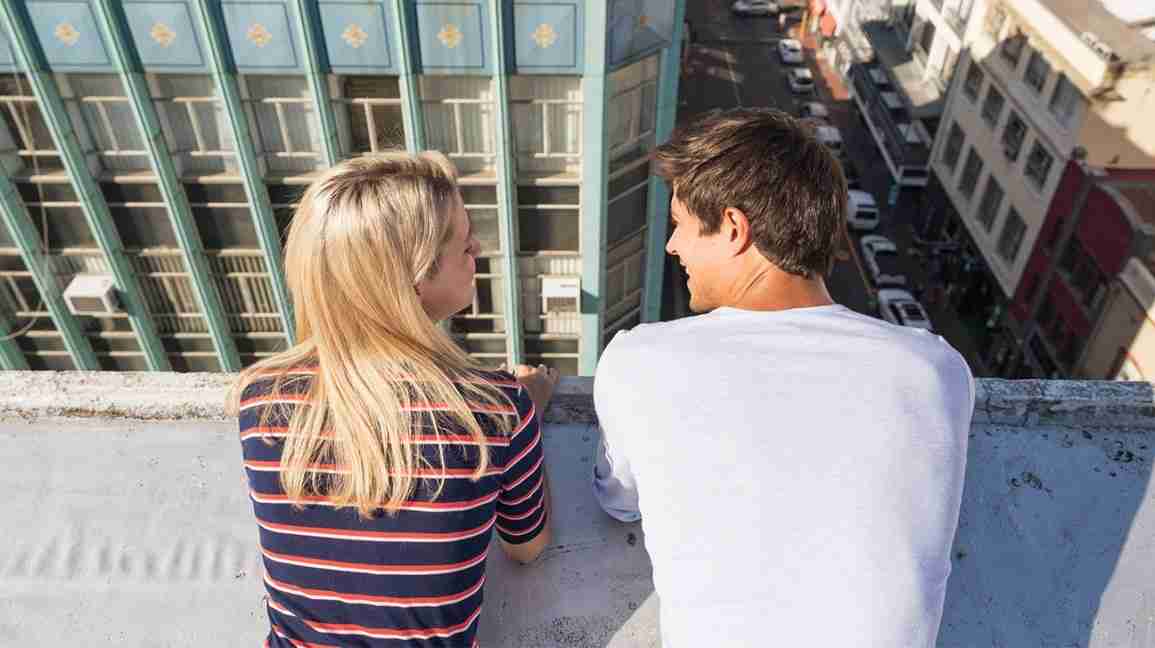 woman and man gaze off rooftop
