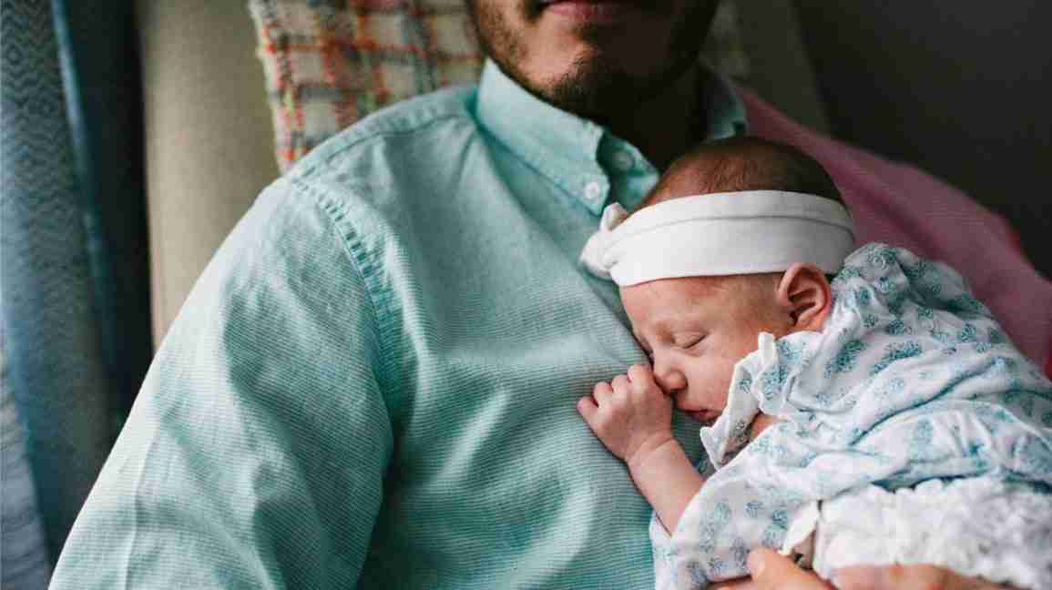 father holds sleeping newborn, preparing for fatherhood