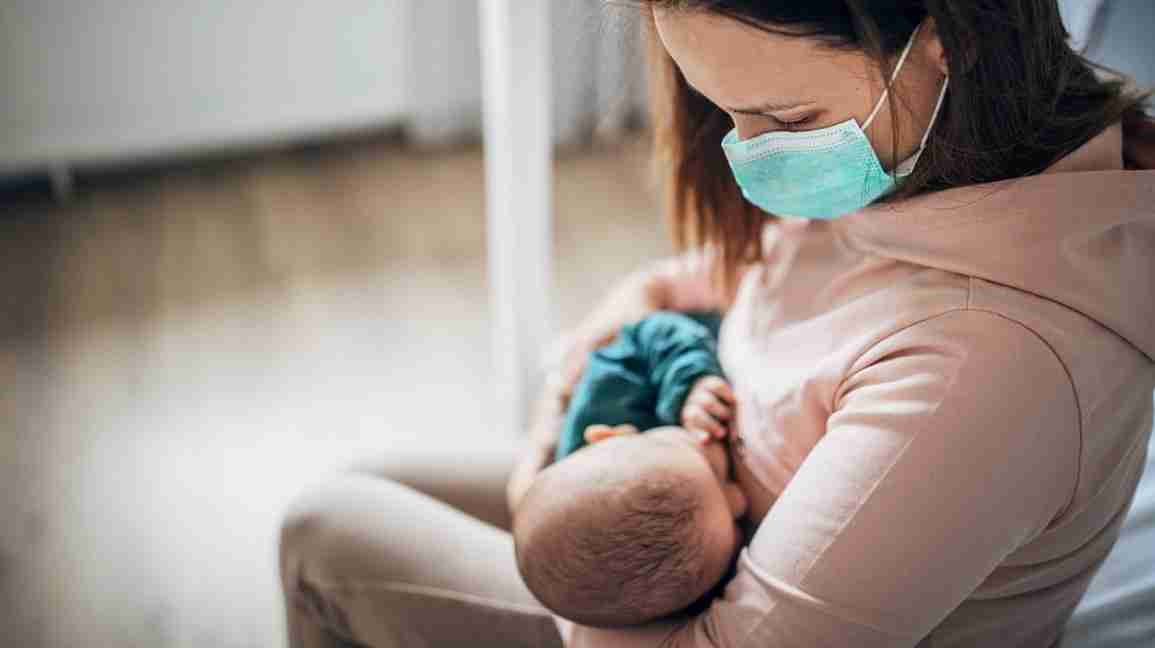 Woman breastfeeding with mask on