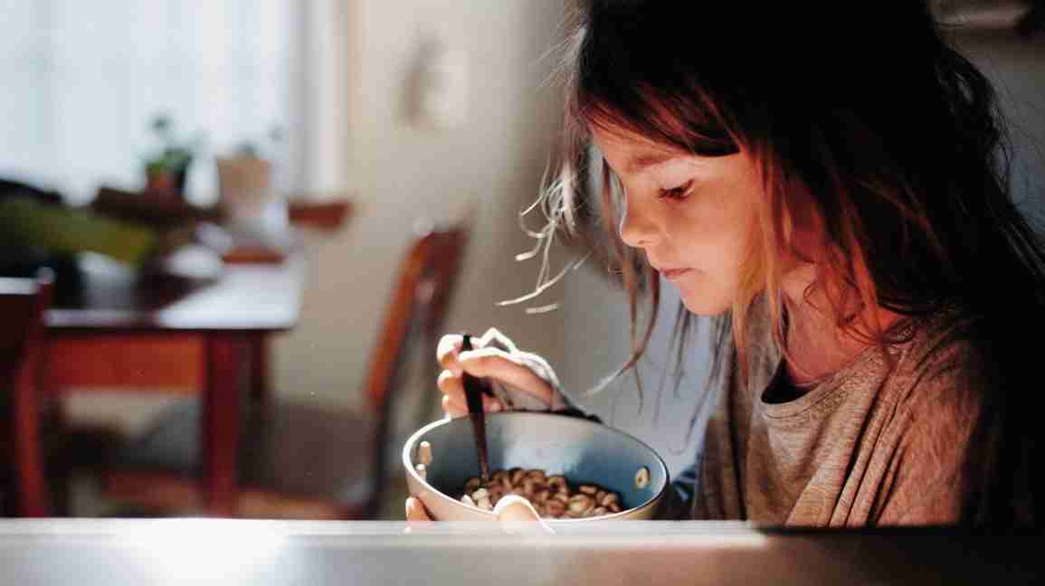 young girl with a bowl of Cheerios 