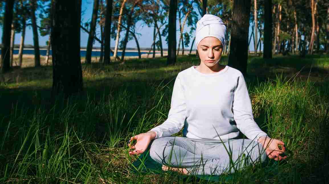 woman practicing kundalini meditation in the grass
