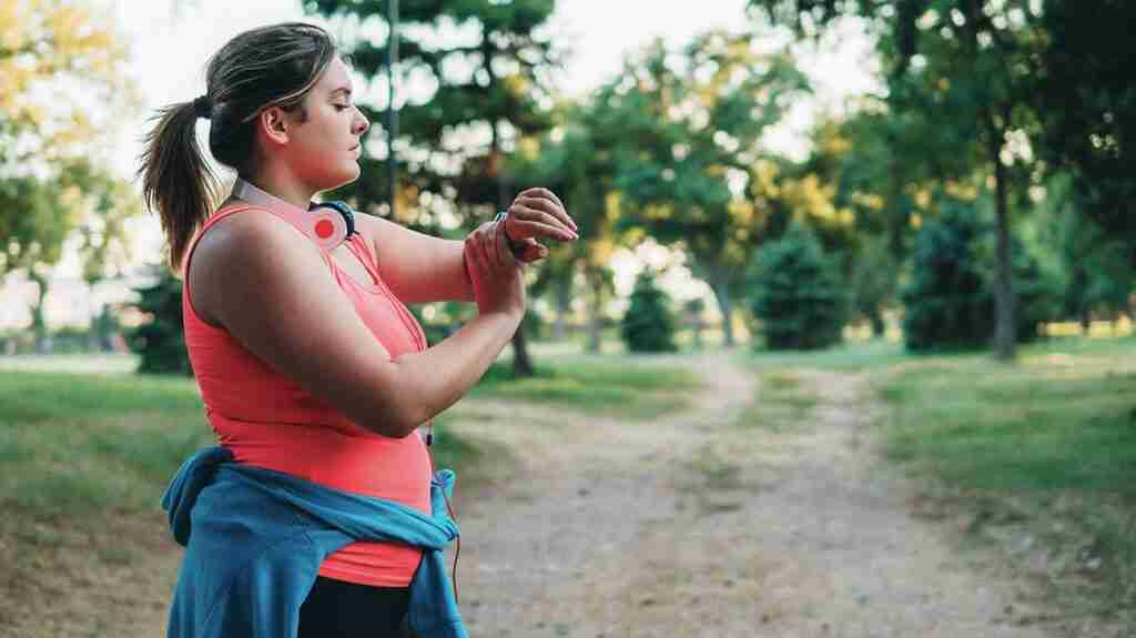An image of a young adult woman on a run to accompany the article, "Weight loss in young adults with obesity may halve mortality risk."