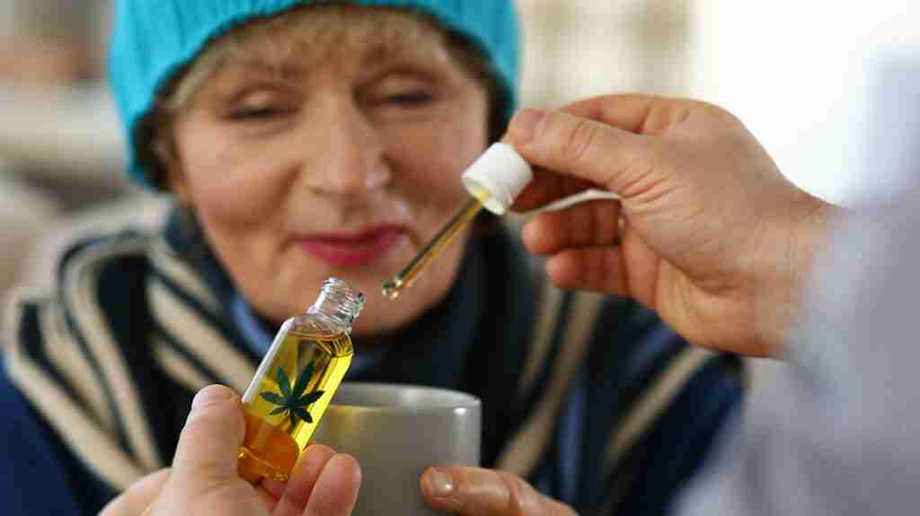 A woman drinks tea with CBD; cannabinoids, including CBD, may interact with prescribed medication.