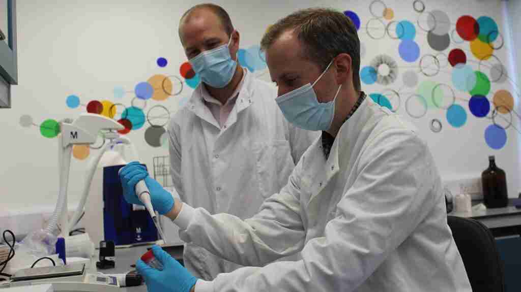 James Hindley, Ph.D working with another scientist in a lab