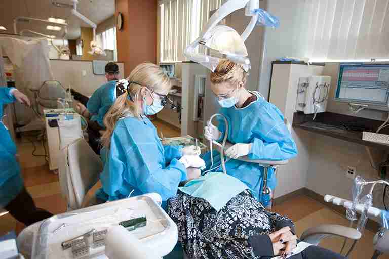 Two dentists work on patient